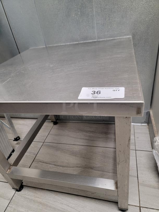 Heavy-duty stainless steel equipment stand with adjustable leveling feet, ideal for heavy machinery or workspace, tag reading "36 QTY".