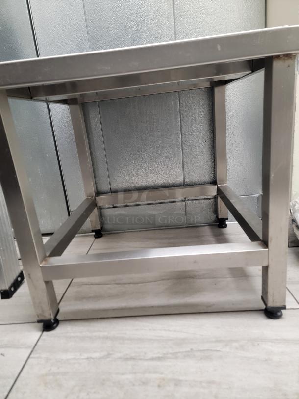 Heavy-duty stainless steel equipment stand with adjustable leveling feet, ideal for kitchen machinery. Durable, easy to clean.