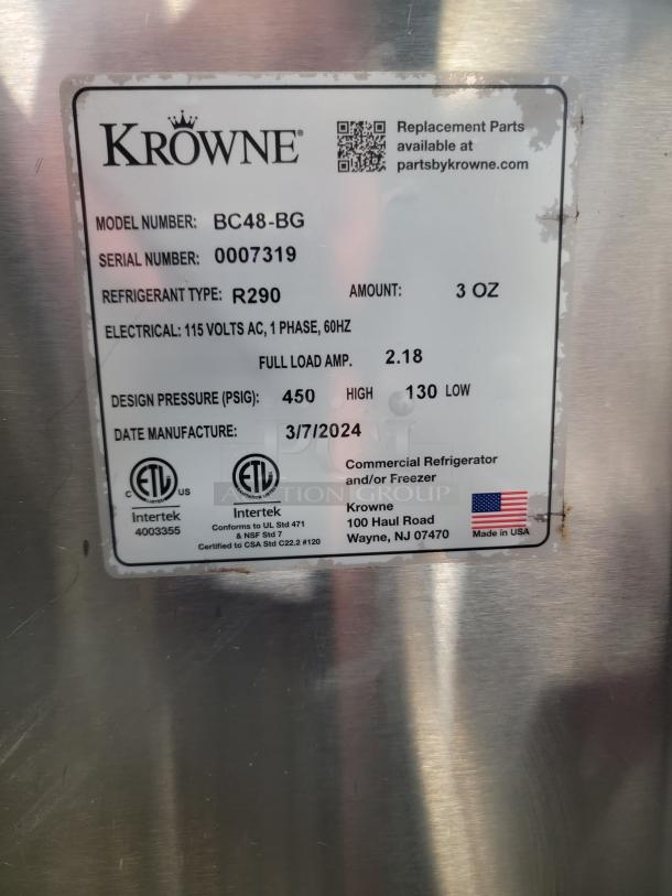 Krowne BC48-BG bottle cooler, black vinyl, stainless steel top, like new. Tag shows model, refrigerant R290, manufactured 2024.