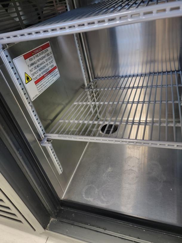 True 3-Door Glass Bar Refrigerator, Model TBR72-RISZ1-L-B-111-1, stainless steel interior, shelving, safety label visible.