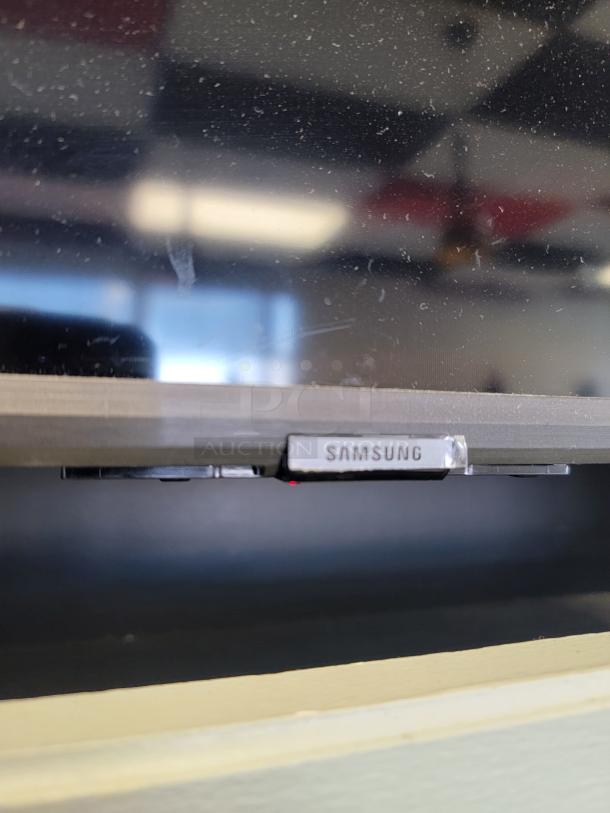 Close-up of a Samsung 65" Smart TV, model UN65TU7000, showing ultra-thin bezel and "Samsung" logo.