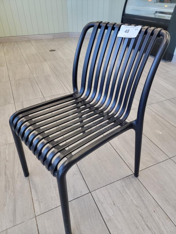 Sleek black slatted bistro chair, commercial grade composite, durable matte finish, ideal for high-traffic areas.