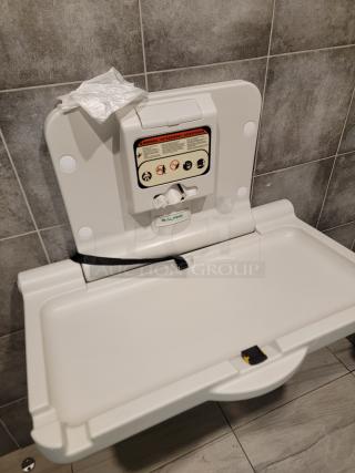 Alpine Industries wall-mounted baby changing station, model 400-01. Clean, durable antimicrobial plastic with liner dispenser and safety straps.