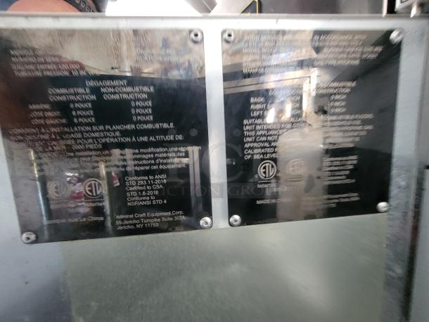 Image showing two metal information plates on a 2021 Covered Wagon mobile food trailer. Plates detail safety standards, certifications (ANSI, CSA, ETL), and manufacturer, Admiral Craft Equipment Corp.