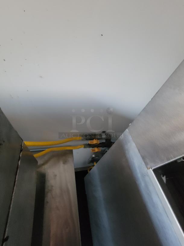 Interior view of a 2021 Covered Wagon 16' mobile food trailer, showing stainless steel surfaces and yellow gas lines.