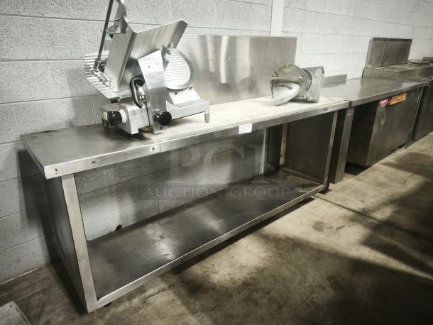 Stainless steel prep table with attached slicer in good condition, featuring a sturdy lower shelf for storage.