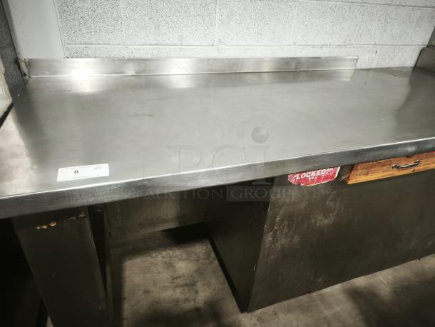 Stainless steel prep table with wooden drawer, good condition, label "8 QTY." Features sturdy build and backsplash.
