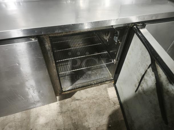 True TPP-93 93" 3-Door Refrigerated Pizza Prep Table, stainless steel, open door showing interior shelves, signs of wear.