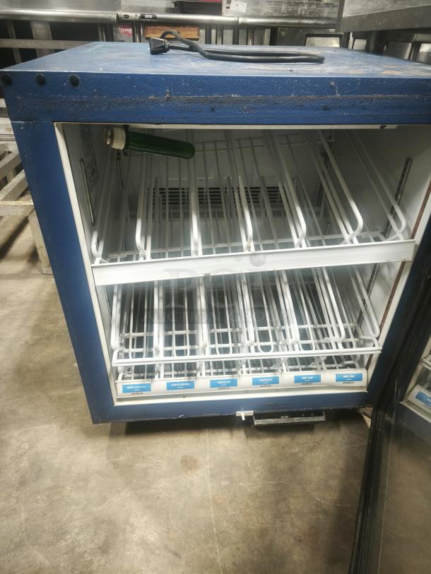 Minus Forty Merchandising Glass Door Freezer, model 07-csgf-x1-frc2, blue finish, empty interior, visible power cord.