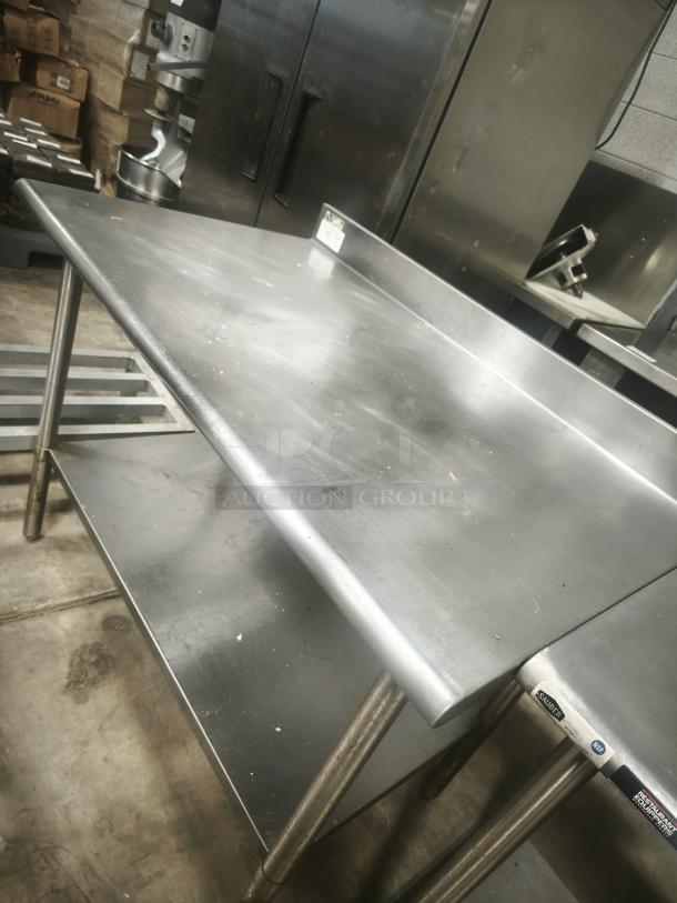 Stainless steel prep table, 30x30x36 inches, features a lower shelf, slight surface wear, ideal for kitchen prep tasks.