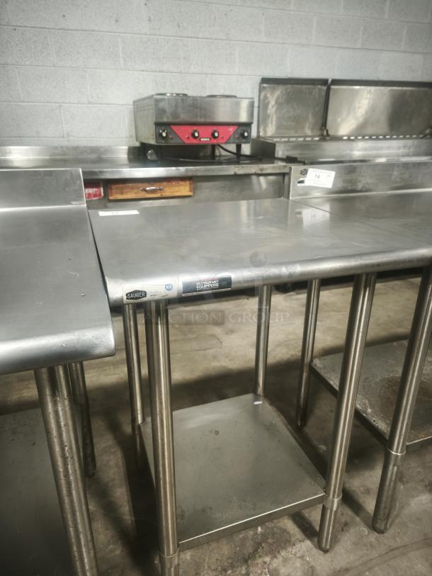 Economy stainless steel prep table, 24x24x36 inches, features durable construction, lower shelf, with minor wear.