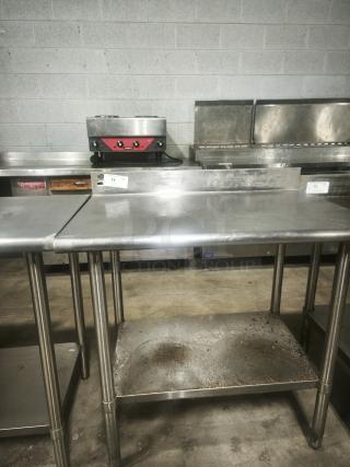 Stainless steel prep table, 36x24x36 inches, used condition. Features durable top and bottom shelf. Auction tag visible.