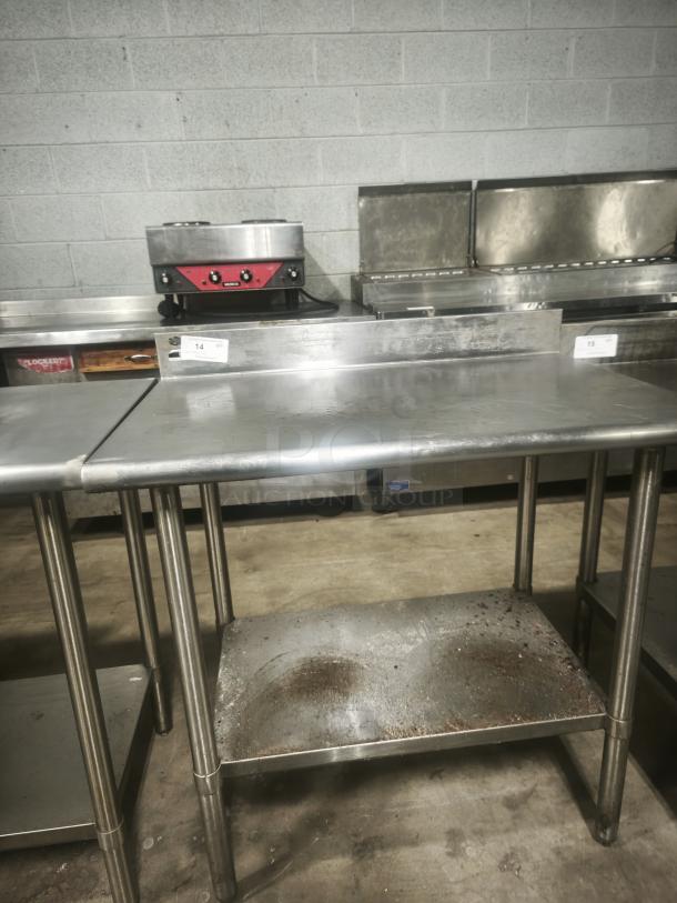 Stainless steel prep table, 36x24x36 inches, with minor surface wear. Durable design with undershelf for storage.