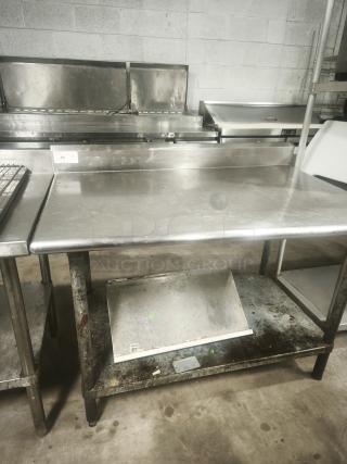 Economy stainless steel prep table, 42x30x34 inches, with under-shelf. Shows signs of use with some rust and dirt.