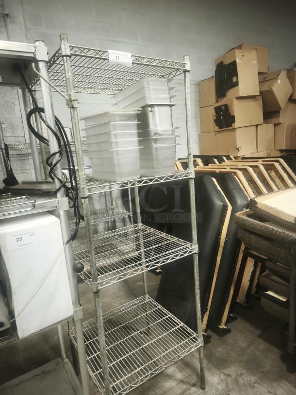 Stainless steel wire shelving unit with four tiers, used condition, includes clear storage bins, label number 21 visible.