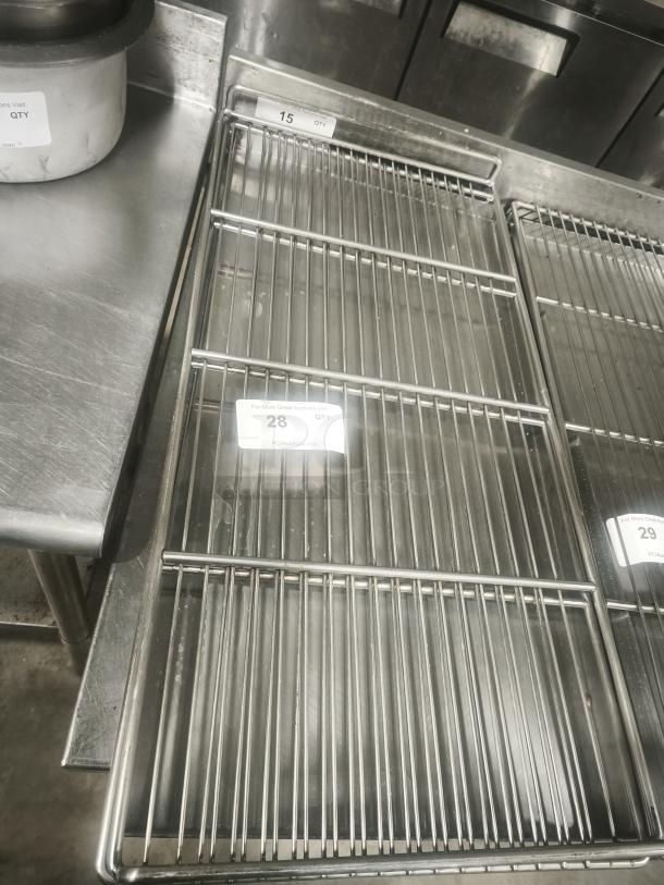 Commercial stainless steel wire racks, excellent condition, with visible auction labels 15, 28, and 29 indicating quantity.