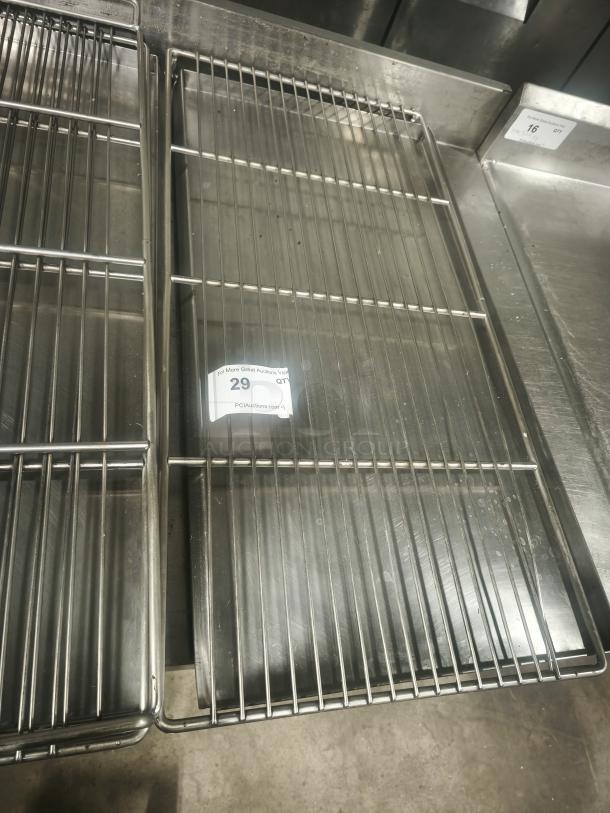 Commercial stainless steel wire rack, rectangular shape, used condition. Auction label with number 29 visible.