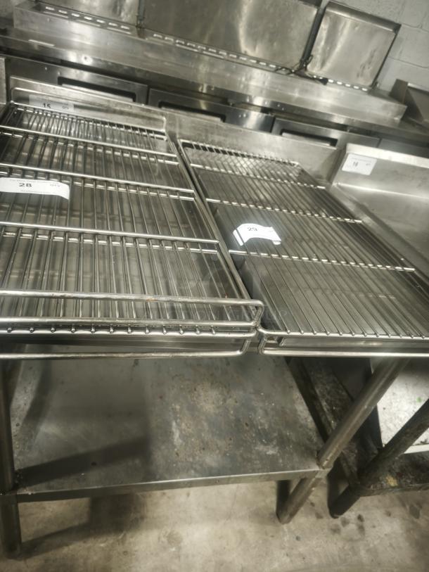 Commercial stainless steel wire racks, used condition, sturdy construction, visible labels indicating item numbers 28 and 23.