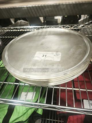 Stack of aluminum pizza pans on a metal shelf, showing label with quantity "31." Smooth surface, good condition.
