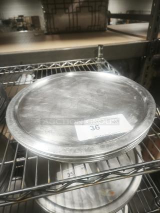 Aluminum pizza pans on metal rack, lightly used, with auction tag showing item number 36 for PCI Auctions.