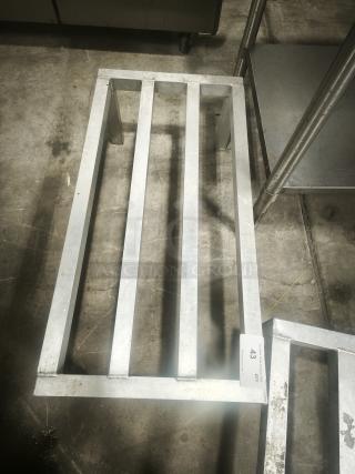 Aluminum dunnage rack for commercial storage, featuring a sturdy metal frame. Good condition with visible use wear.