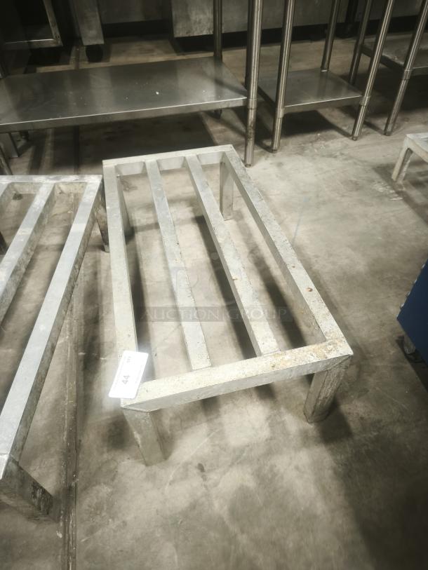 Aluminum dunnage rack for commercial storage, used condition, sturdy construction, visible tag marked "44".