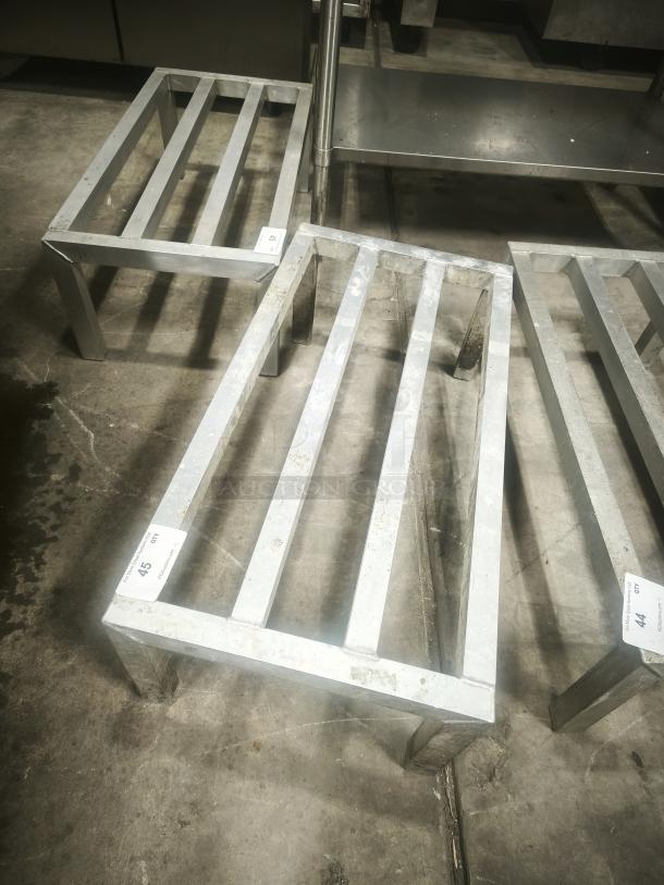 Aluminum dunnage rack for commercial storage, rectangular with slatted top, shown in used condition with some visible wear.