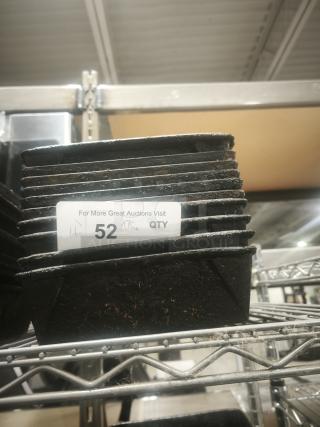 Stack of enamelware tin plate pans on metal shelf, showing wear. Label indicates quantity as 52.