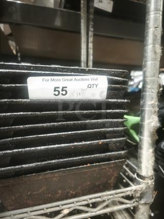 Stack of enamelware tin plate pans, showing signs of rust and wear, placed on a metal shelf. Numbered label "55" visible.