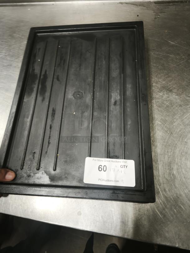 Black plastic tray or lid with ridges, rectangular, 17"x12". Visible label shows auction number and website. Good condition.