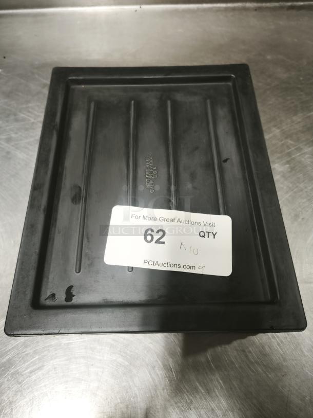 Multi-purpose black plastic tray or lid with ribbed design, visible wear, and auction label reading "62 QTY."
