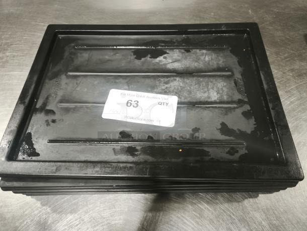 Black multi-purpose plastic tray or lid shown on a metal surface. Sticker with auction info and item number 63 visible.