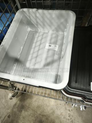 Gray commercial plastic utility bus tub on a metal rack, showing light wear. Auction tag reading "69 QTY" visible inside.