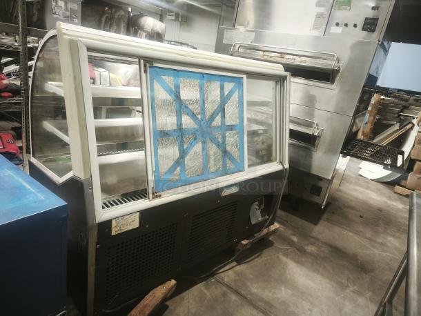 Turbo Air TD-5R curved glass deli display case, 59", features glass damage, multiple shelves, industrial setting.