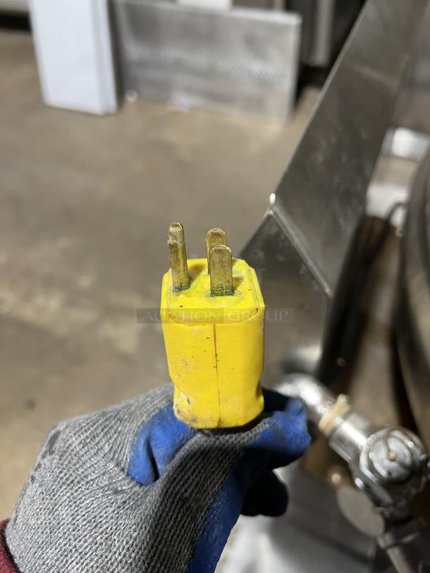 Yellow industrial plug attached to Groen DH/1-40 commercial stainless steel tilting steam kettle.