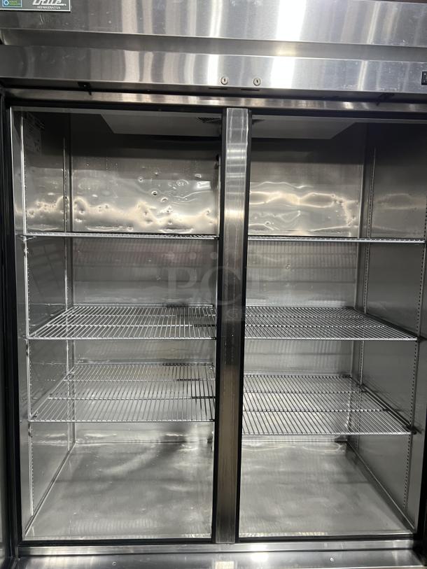 True T49HC commercial stainless steel 2-door reach-in refrigerator with poly-coated wire racks, on casters, 115V, 1 phase.