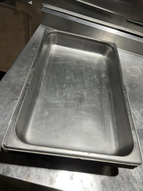 Commercial stainless steel stackable steam table pan, rectangular shape, used condition, visible surface scratches.