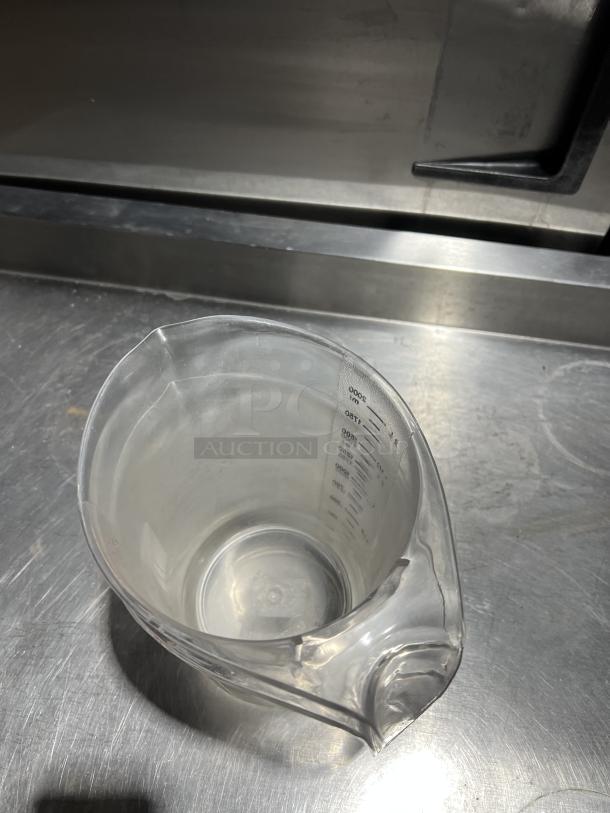 Clear polycarbonate 2 qt. measuring cup by Choice, marked with measurements, good condition, ideal for commercial use.