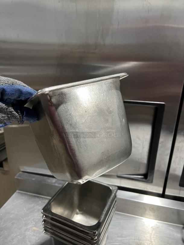 Stainless steel steam table pan, commercial grade, stackable, visible wear, suitable for food service.