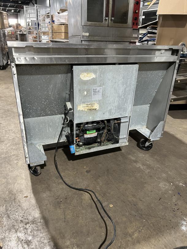 Randell 2-door stainless steel worktop refrigerator, Model 9302-7, on casters, 115V, used condition with visible wiring and labels.