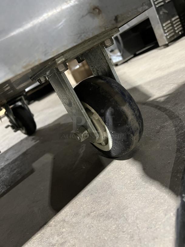 FWE PH182618 stainless steel heated holding cabinet on casters, features built-in pan slides, 120V, visible caster detail.