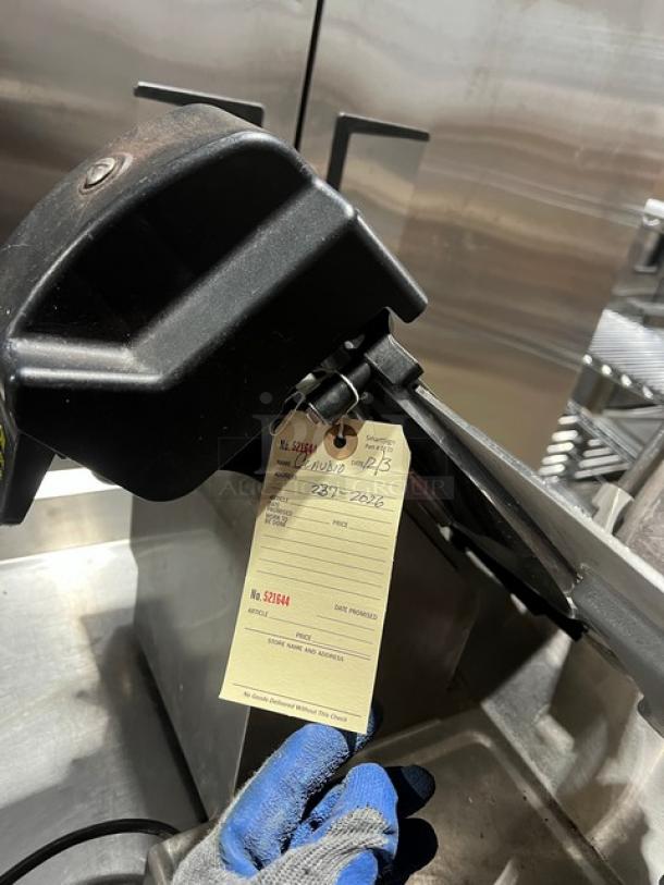 Globe electric countertop meat deli slicer on legs, visible inspection tag attached.