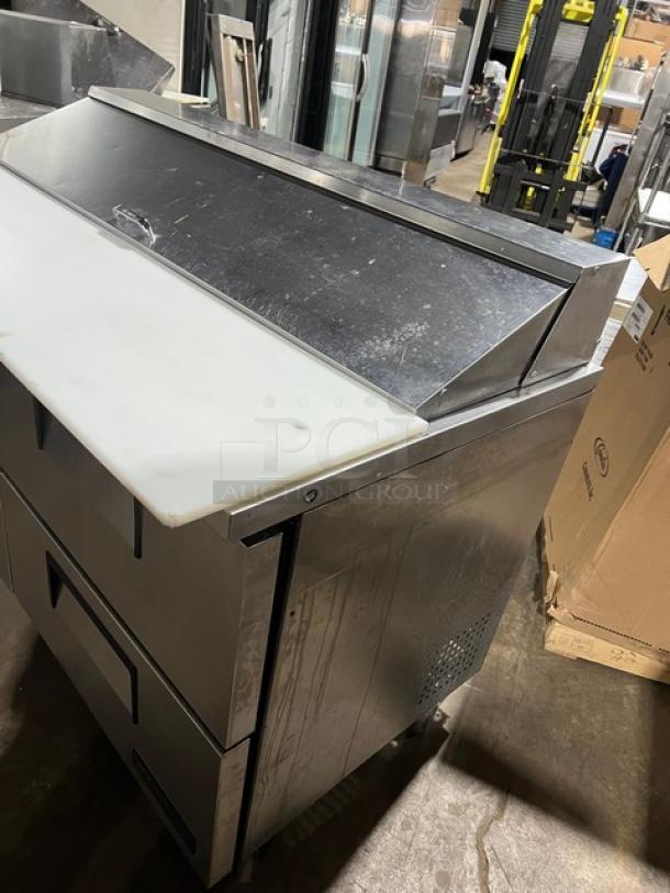 True TSSU-60-16D-4 refrigerated prep table, stainless steel, four drawers, bain marie style, with cutting board, on casters.