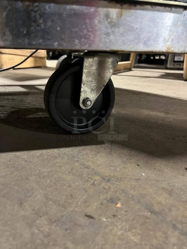 True TSSU-60-16D-4 stainless steel 4-drawer refrigerated prep table with cutting board, on casters, model visible.