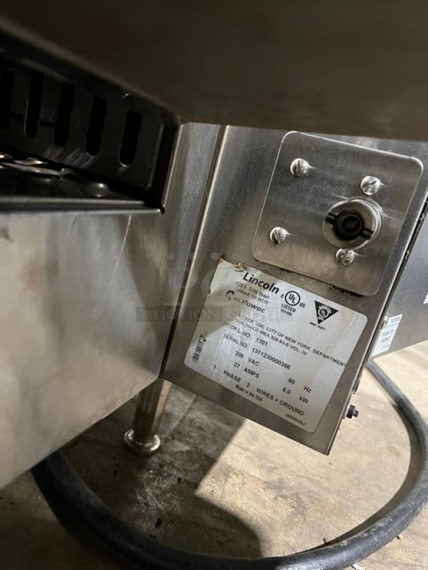 Lincoln model 1301 stainless steel electric countertop impinger conveyor oven, 208V, 1 phase, on legs, visible serial number.