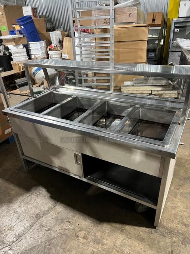 Atlas Metal 4-well stainless steel hot food steamtable with sneeze guard, tray slide, enclosed storage base, model WIHDM4.