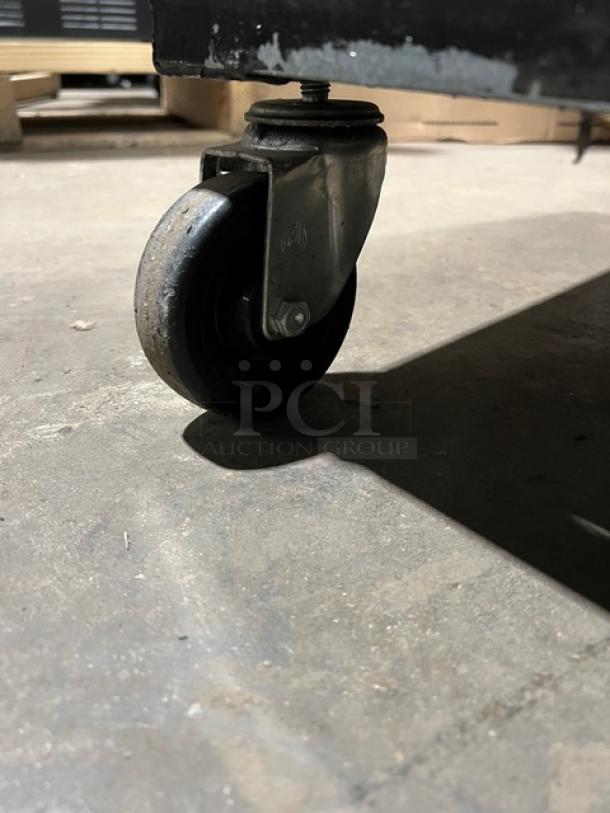 True T-23 Commercial Refrigerator caster detail; sturdy design, stainless steel build, poly coated wired rack, S/N 1-3522772.