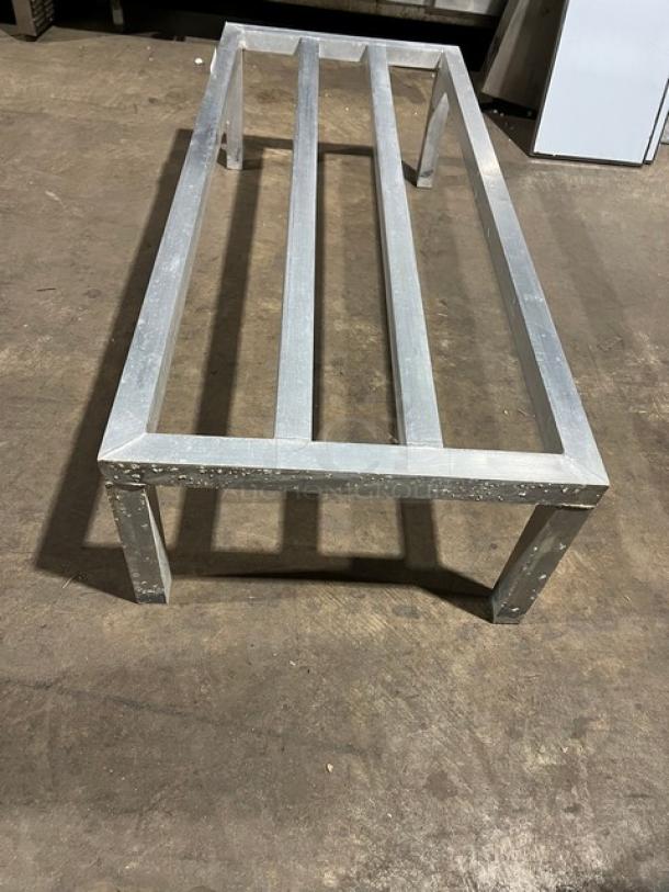 Commercial heavy-duty aluminum dunnage rack on legs, rectangular frame, used condition with visible wear, ideal for storage.
