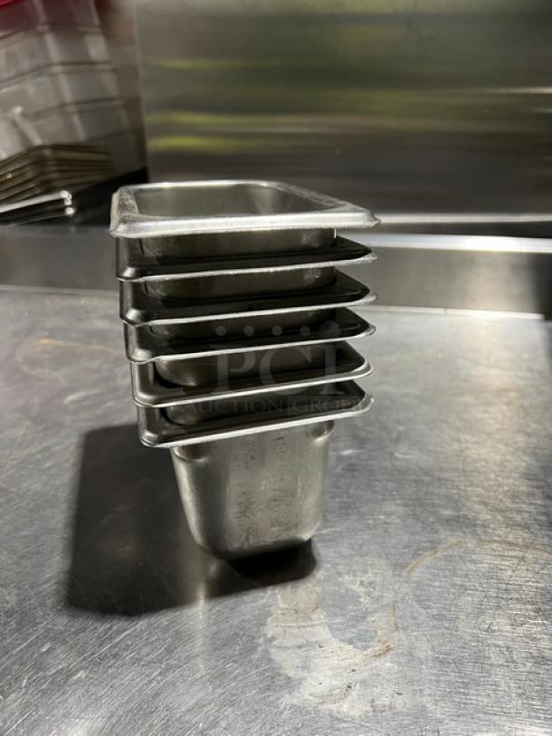 Stack of Vollrath Super Pan V Series 1/9-Size stainless steel pans, model 30942, used condition.