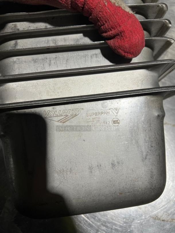 Vollrath Super Pan V Series stainless steel 1/9-size pan, model 30942. Visible brand and model markings. Slight wear.